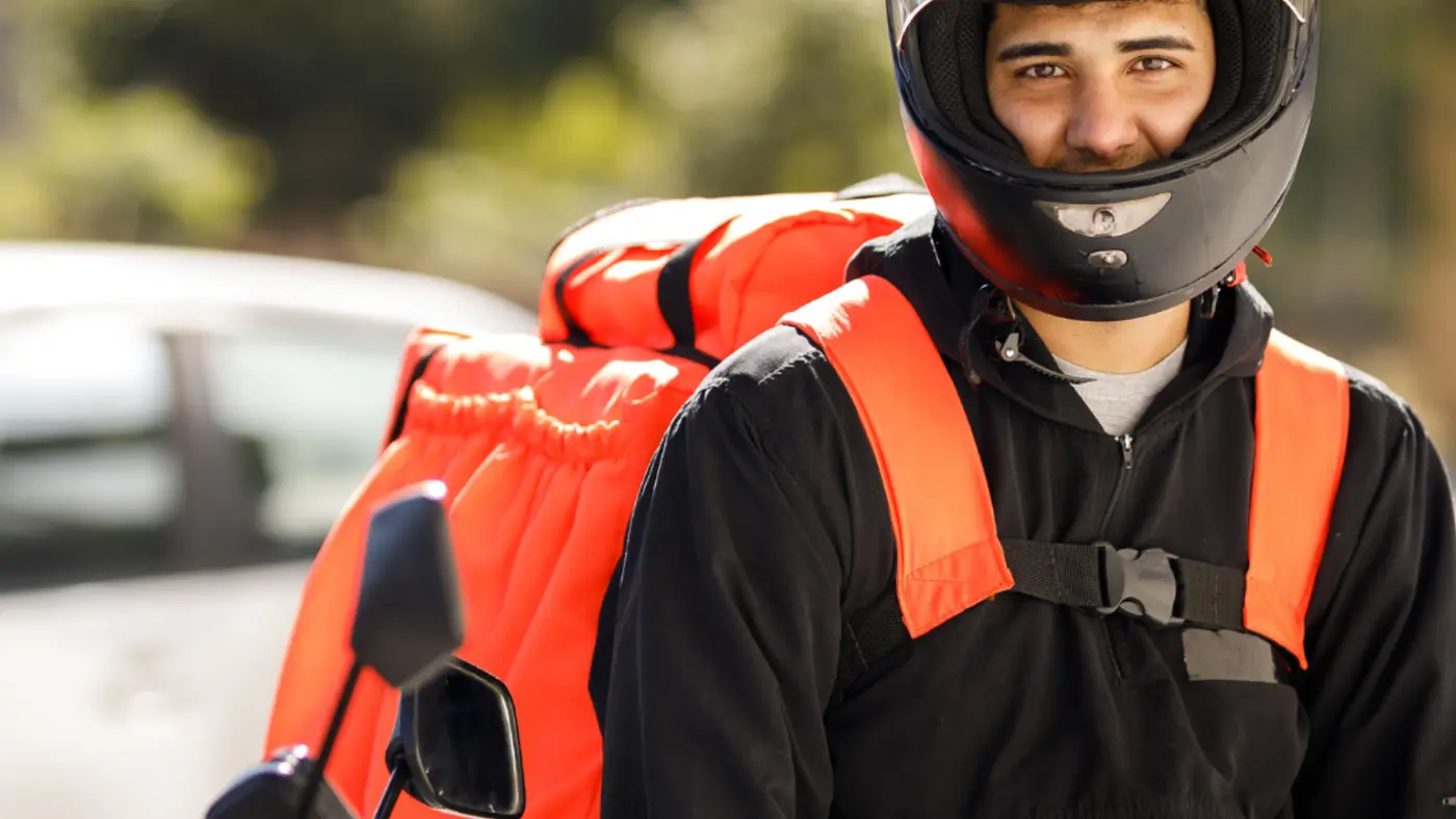Entregador de delivery com capacete e mochila térmica